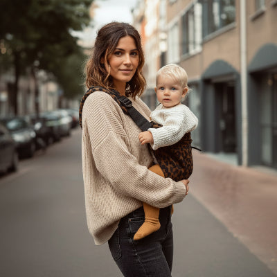 Maman en ville avec bebe en echarpe de portage