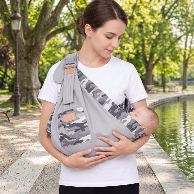 Maman se promène dans un parc urbain avec son bébé dans une écharpe de portage - balade grise 