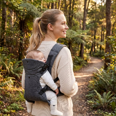Maman en foret avec bebe au dos en porte bebe adaptable