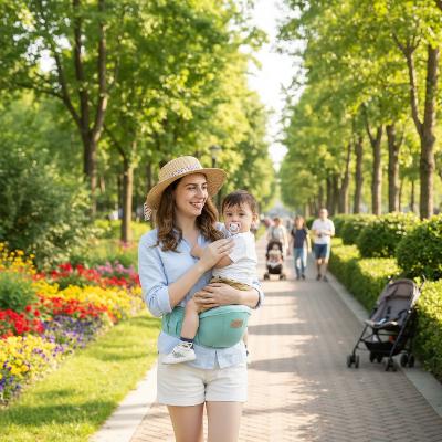 Maman en parc avec bebe en porte bebe confort vert