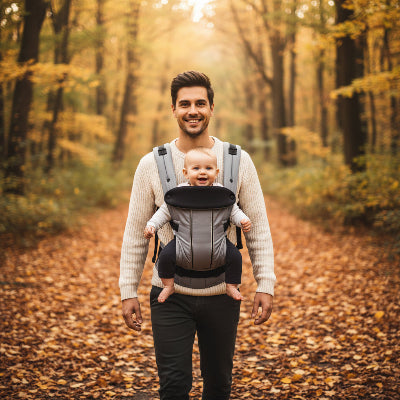 Papa en foret automnale avec bebe en porte bebe physiologique gris